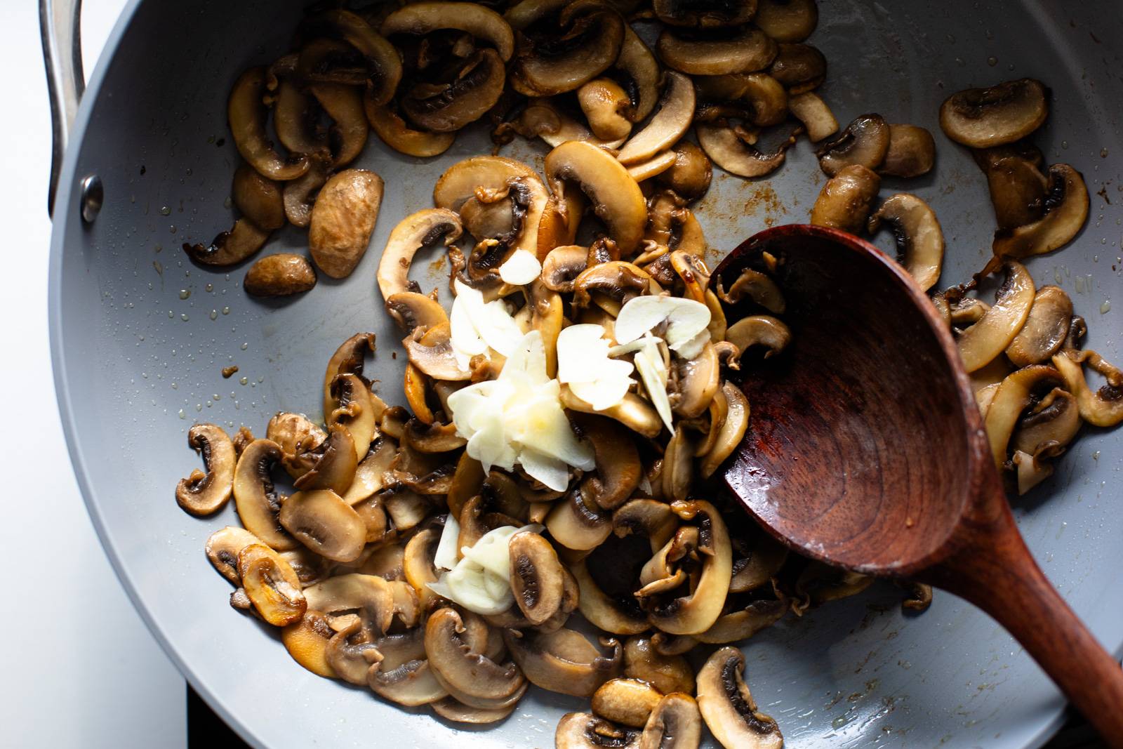 Sautéing mushrooms and garlic in a nonstick pan.