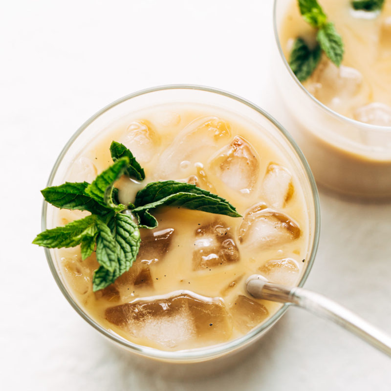 Vanilla mint iced coffee in a glad with ice and mint sprigs.